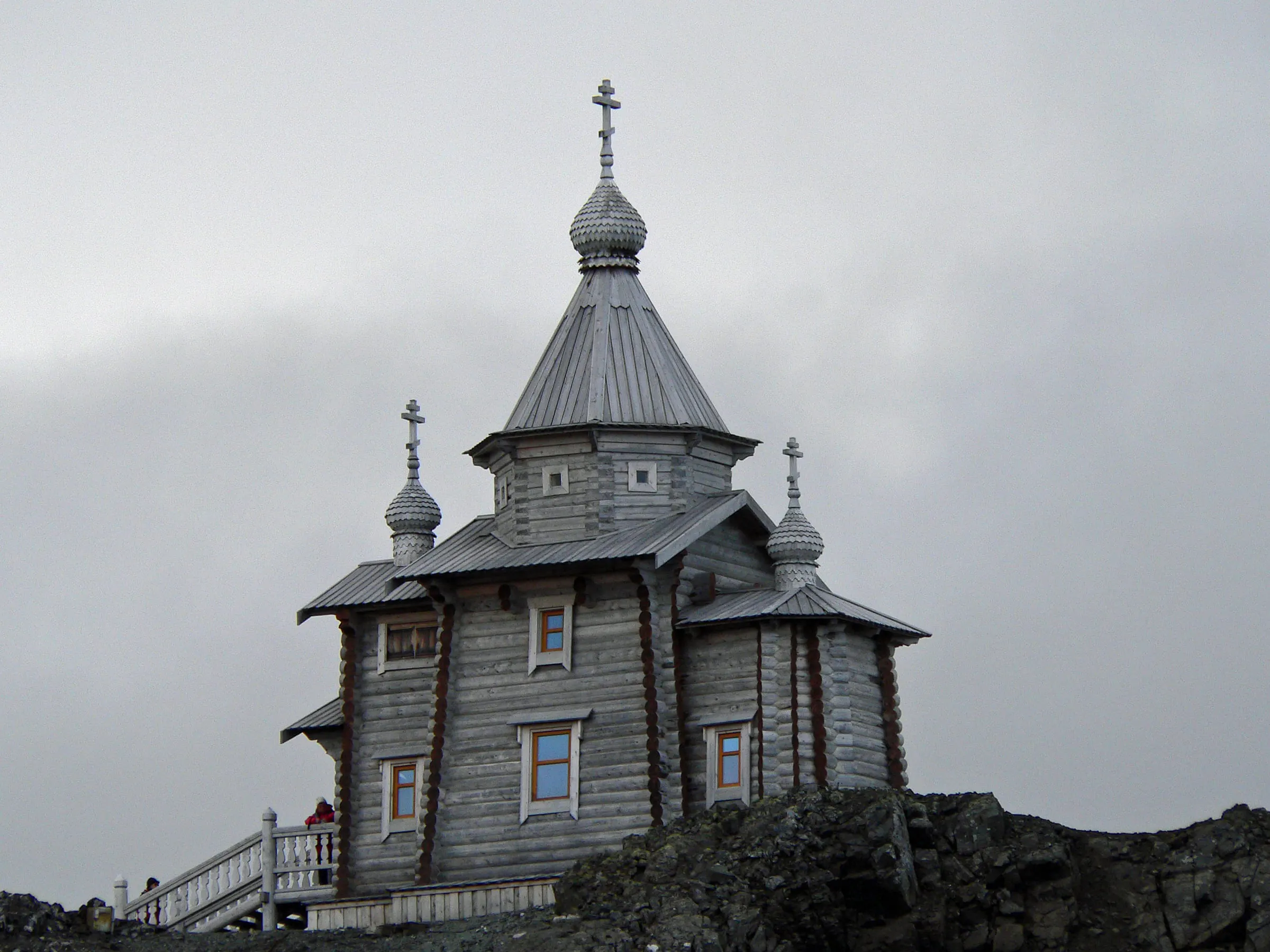 The wooden Holy Trinity Church with its small onion domes stands on a rocky hill at Bellingshausen Station on King George Island.